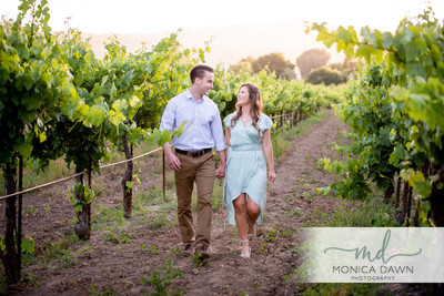 Newly engaged couple walking through a vineyard in Gilroy CA