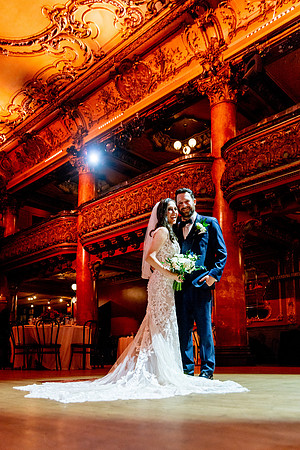 Romantic couple portrait under stage lighting inside the Great American Music Hall.